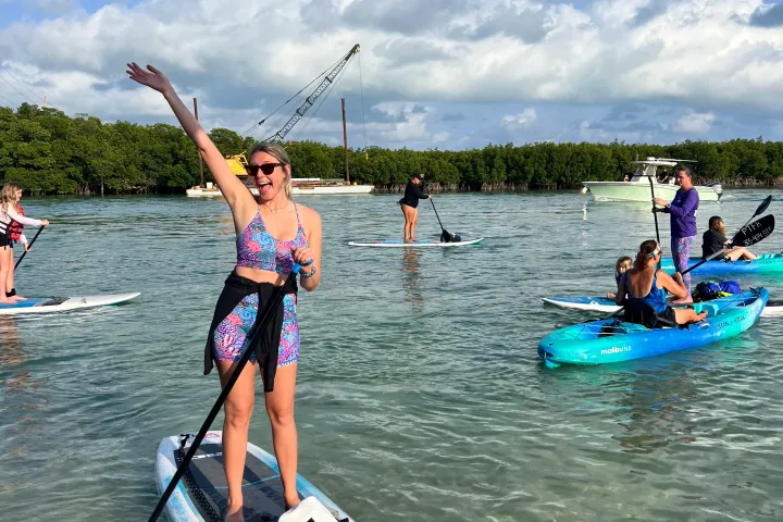 a group of people riding on the back of a boat in the water